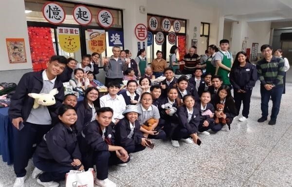 一群穿著制服的學生與長輩在「憶起愛柑仔店」佈景前開心合影。